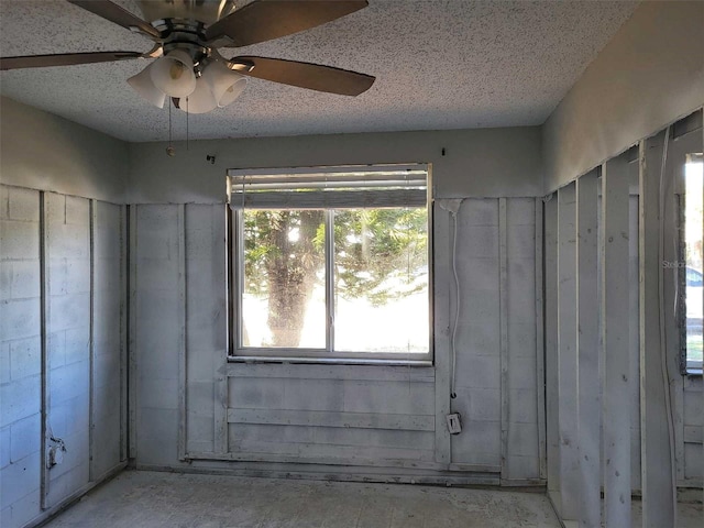 empty room with a ceiling fan and a textured ceiling