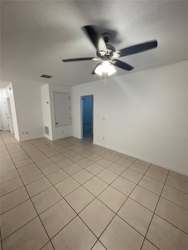 unfurnished room with ceiling fan, visible vents, and light tile patterned flooring