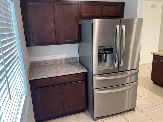 kitchen featuring light tile patterned floors, light countertops, dark brown cabinets, and stainless steel refrigerator with ice dispenser