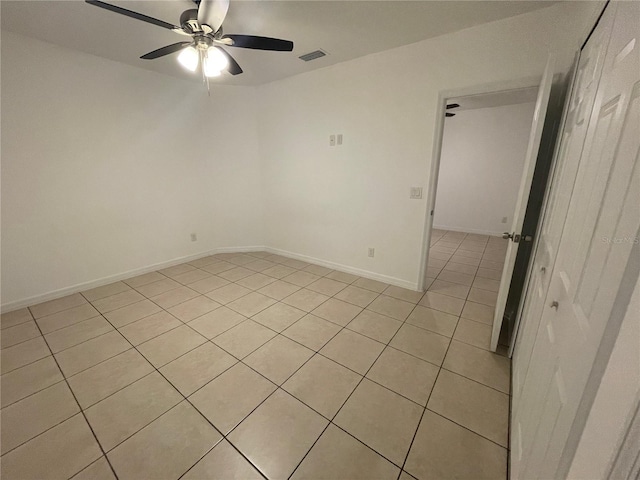 spare room with a ceiling fan, visible vents, and baseboards