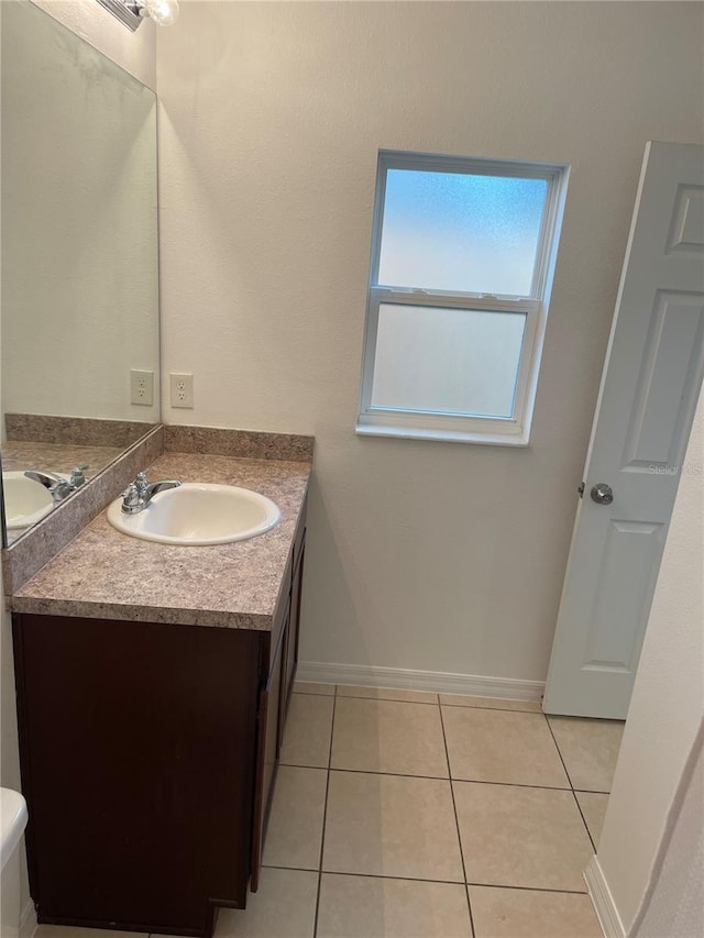 bathroom with tile patterned flooring, vanity, and baseboards