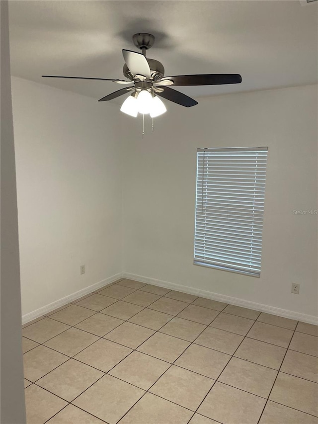 empty room featuring ceiling fan and baseboards