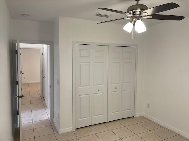 unfurnished bedroom with light tile patterned floors, baseboards, visible vents, and a closet