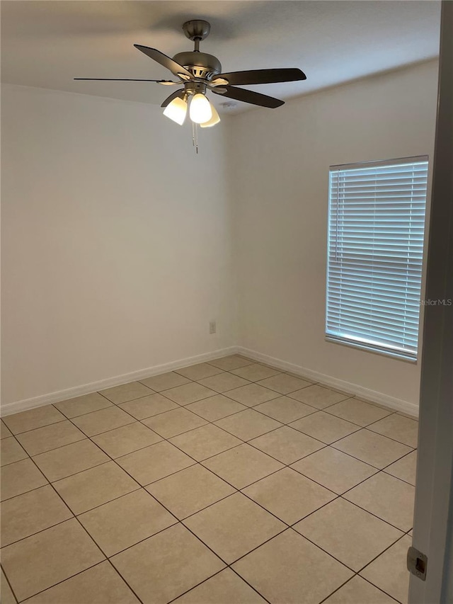 empty room with ceiling fan and baseboards