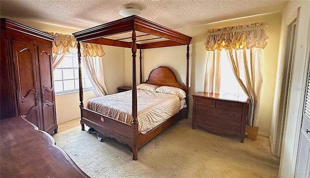 bedroom featuring light colored carpet and a textured ceiling