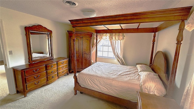 bedroom with visible vents, light carpet, and a textured ceiling