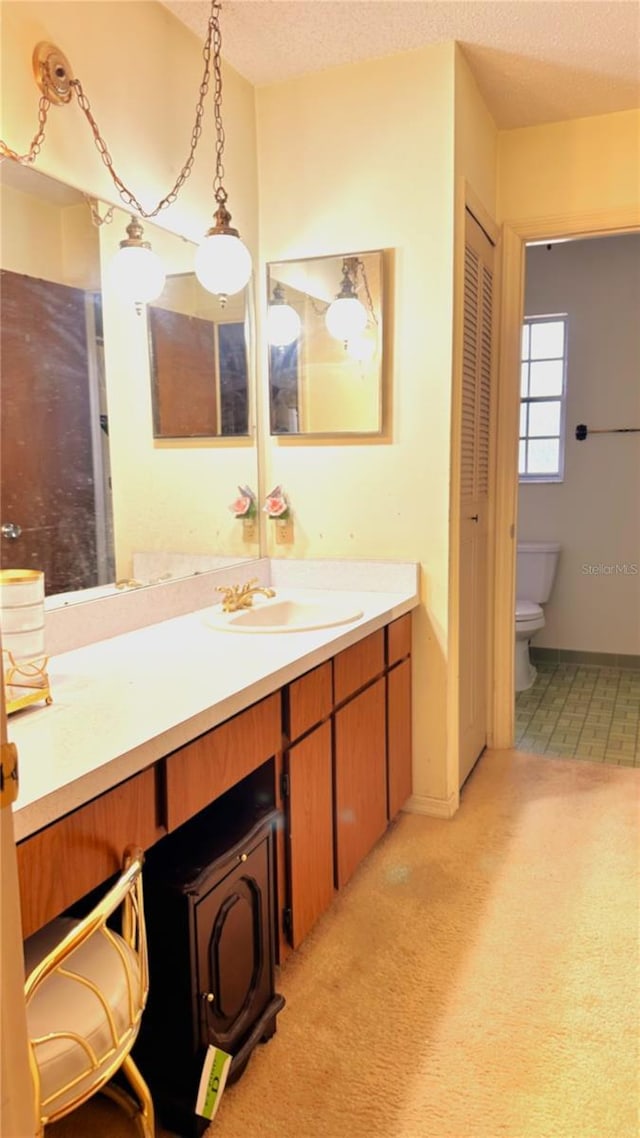 full bath with a textured ceiling, toilet, vanity, baseboards, and a closet