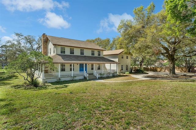 rear view of property with a porch, a yard, and a chimney