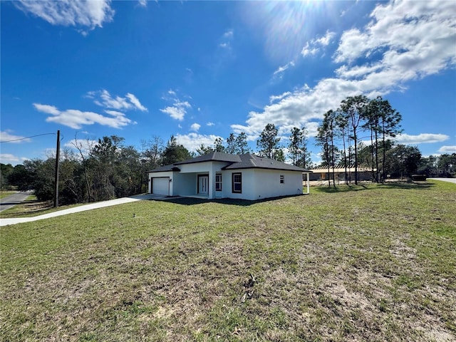 single story home featuring a garage, a front lawn, concrete driveway, and stucco siding