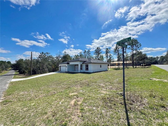 view of front facade with a garage, driveway, and a front lawn