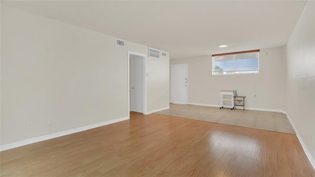 spare room with light wood-type flooring, baseboards, and visible vents