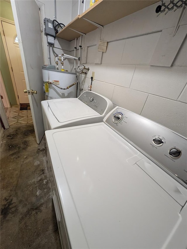 laundry room with concrete block wall, laundry area, gas water heater, and separate washer and dryer