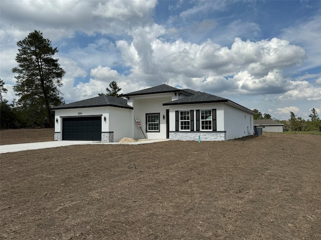 view of front of home featuring a garage, stone siding, concrete driveway, and stucco siding