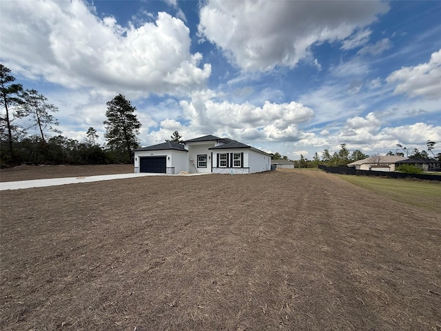 view of front of property featuring a garage, stucco siding, concrete driveway, and a front yard