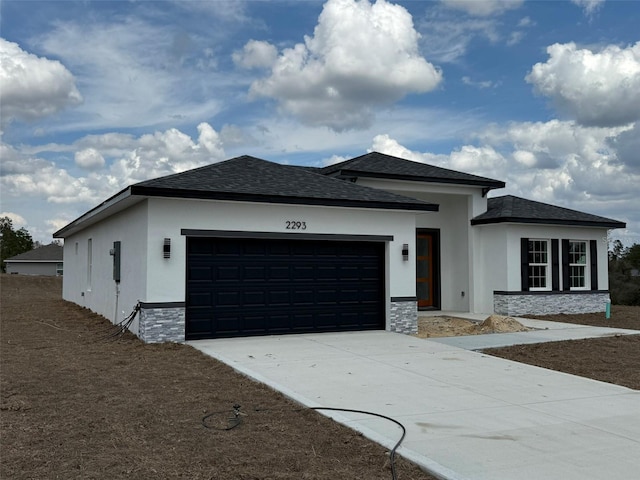 view of front of home with roof with shingles, stucco siding, concrete driveway, an attached garage, and stone siding