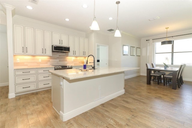 kitchen with tasteful backsplash, ornamental molding, stainless steel appliances, light wood-type flooring, and a sink