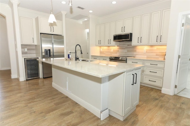 kitchen with wine cooler, visible vents, light wood-style flooring, appliances with stainless steel finishes, and a sink