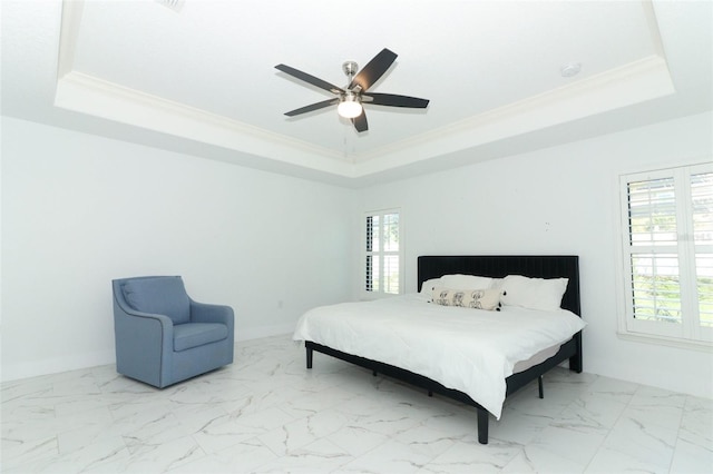 bedroom with ornamental molding, multiple windows, a raised ceiling, and baseboards