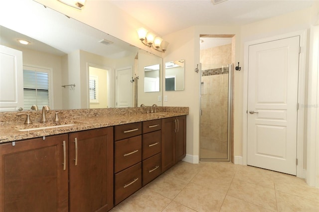 bathroom with a stall shower, visible vents, and a sink