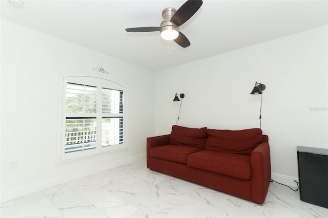 living room featuring ceiling fan, marble finish floor, and baseboards