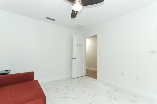 interior space with a ceiling fan, marble finish floor, visible vents, and baseboards