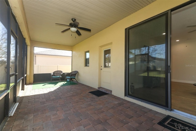 unfurnished sunroom with a ceiling fan