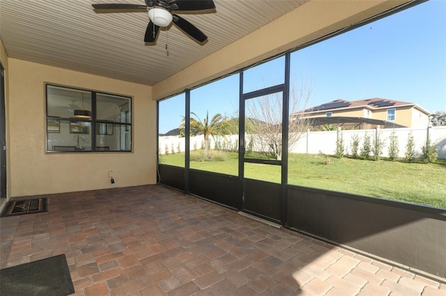 unfurnished sunroom with ceiling fan and visible vents