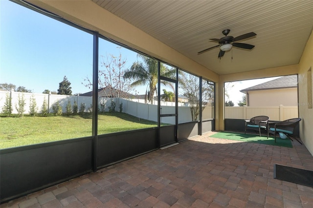 unfurnished sunroom featuring ceiling fan