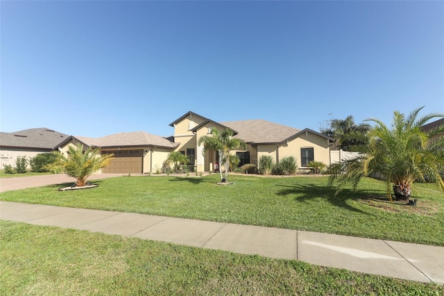 view of front of home featuring a garage, driveway, a front yard, and stucco siding