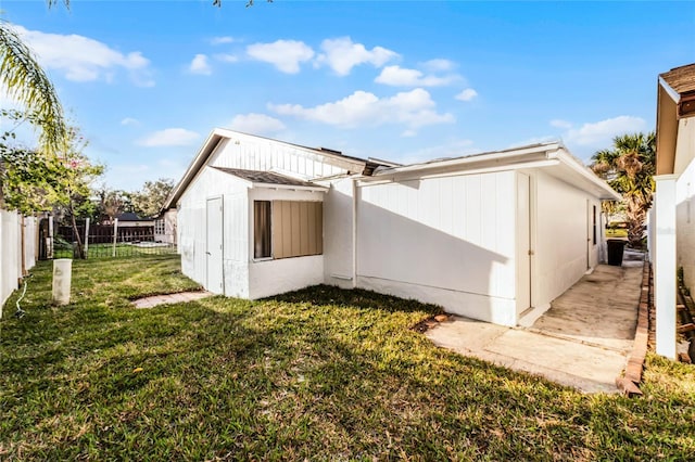 rear view of property with fence and a yard