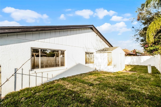 view of property exterior with a lawn and fence