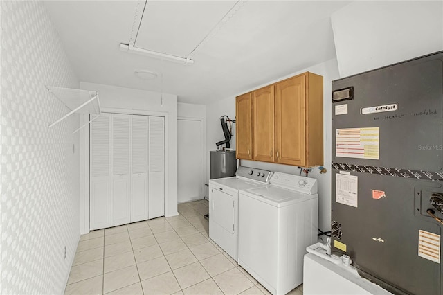 washroom with heating unit, light tile patterned floors, cabinet space, attic access, and separate washer and dryer