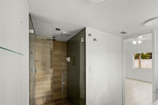 bathroom featuring ceiling fan, a stall shower, wood finished floors, and visible vents