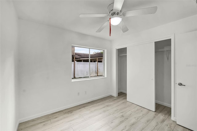 unfurnished bedroom featuring light wood-style floors, a closet, ceiling fan, and baseboards