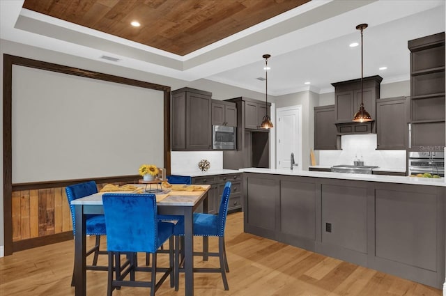 kitchen with light countertops, appliances with stainless steel finishes, a raised ceiling, and visible vents