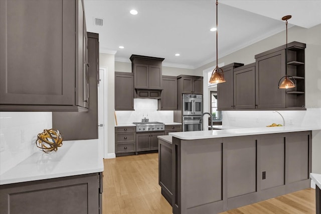 kitchen with open shelves, light countertops, hanging light fixtures, appliances with stainless steel finishes, and a peninsula