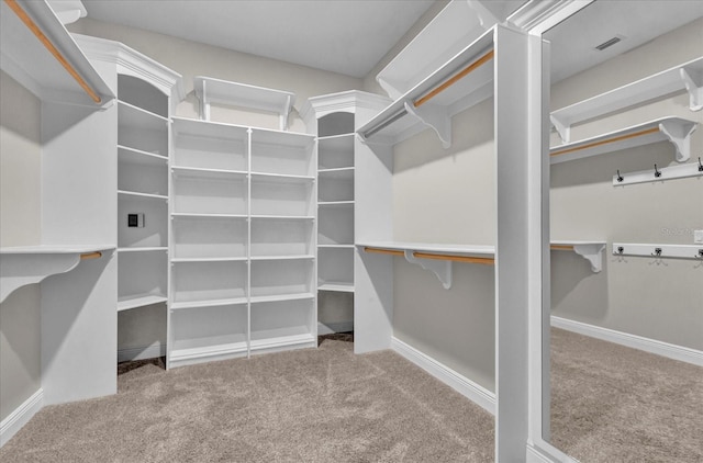 walk in closet featuring light carpet and visible vents