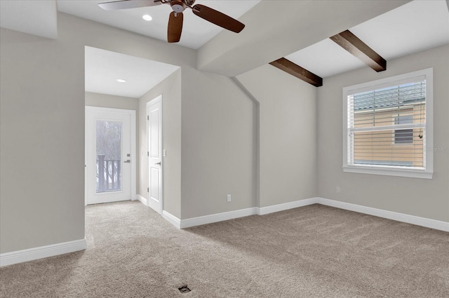 empty room featuring baseboards, beamed ceiling, and light colored carpet