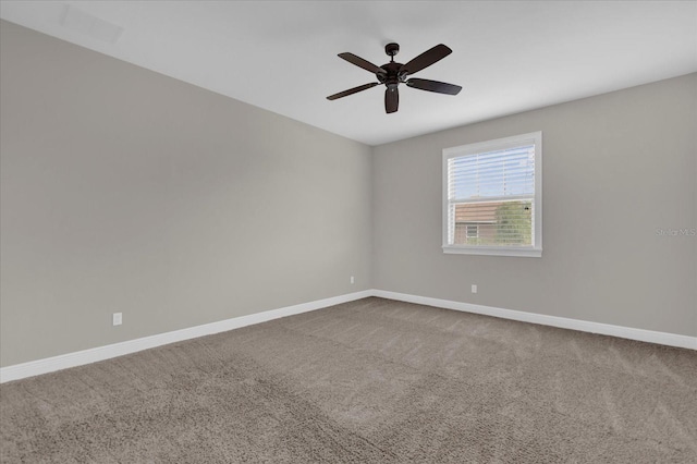 spare room featuring carpet floors, a ceiling fan, and baseboards