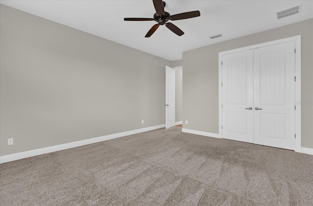 unfurnished bedroom featuring baseboards, a closet, visible vents, and carpet flooring