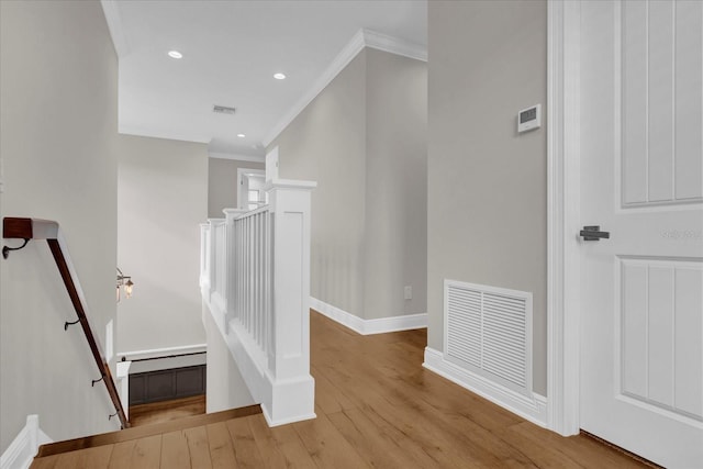 stairway with baseboards, visible vents, wood finished floors, crown molding, and recessed lighting