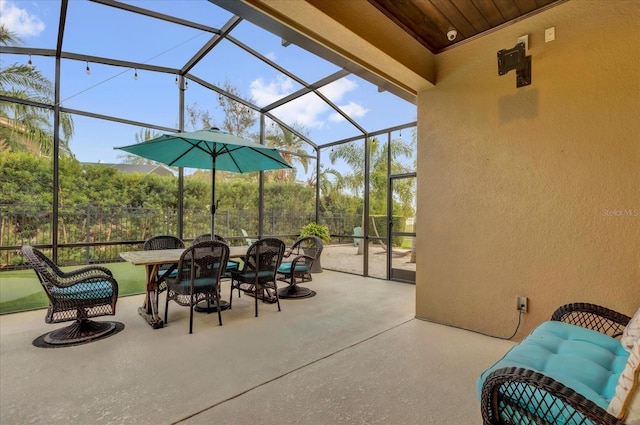 view of patio / terrace featuring a lanai and fence