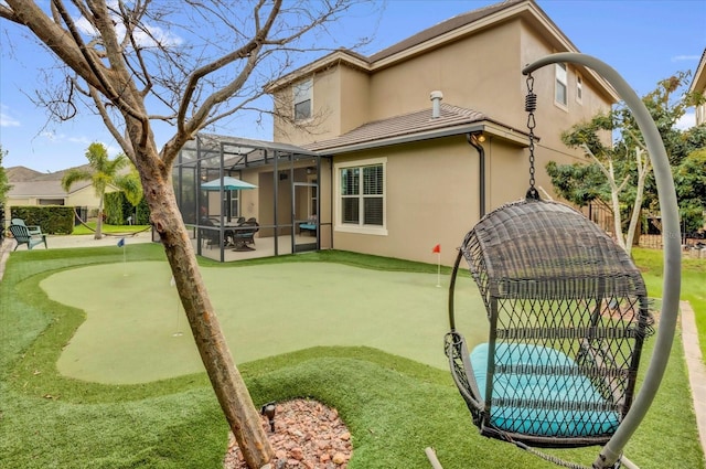 back of property with a lanai, fence, and stucco siding