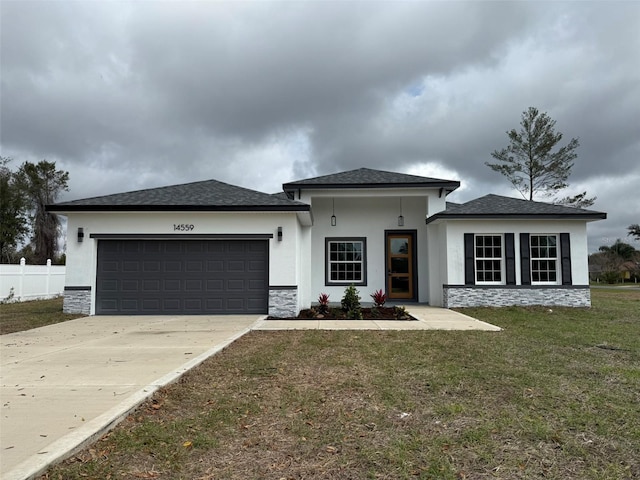 prairie-style house featuring a front lawn, concrete driveway, stucco siding, a garage, and stone siding