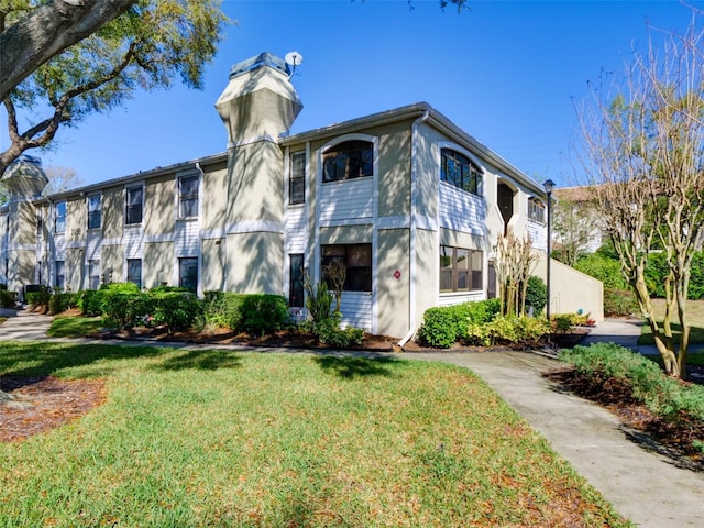 view of property with a front lawn and stucco siding