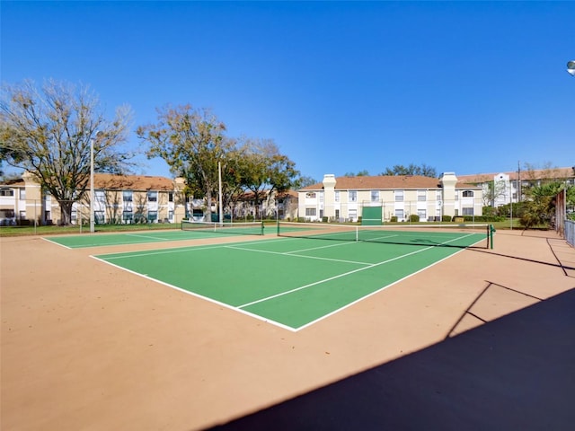 view of sport court with a residential view and fence