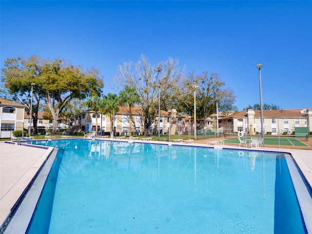 community pool featuring fence and a residential view