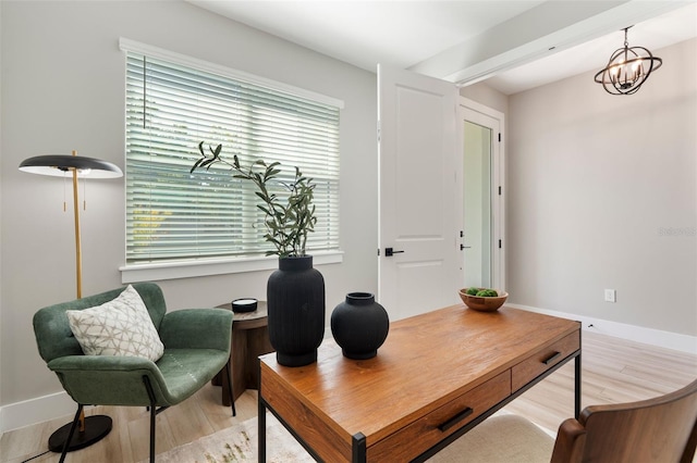 home office with baseboards, a notable chandelier, and light wood-style floors