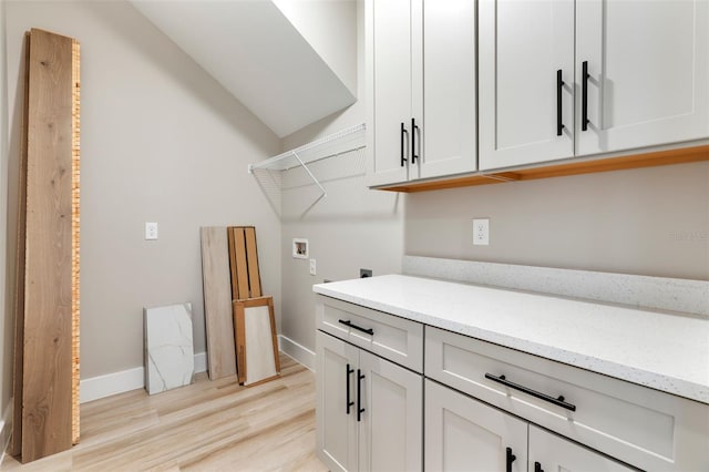 laundry area featuring cabinet space, baseboards, hookup for an electric dryer, light wood-type flooring, and washer hookup