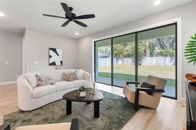 living room with recessed lighting, baseboards, and wood finished floors